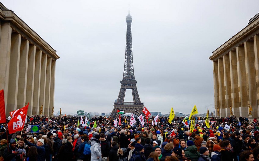 Thousands of people protest near the Eiffel Tower in Paris
